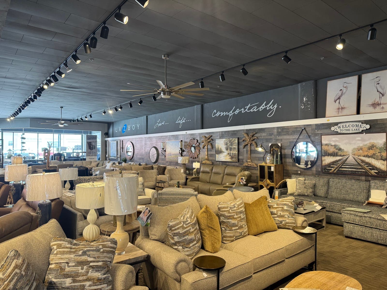 La-Z-Boy living room display with sofas, recliners and lake-themed art at Seneca Furniture Showcase