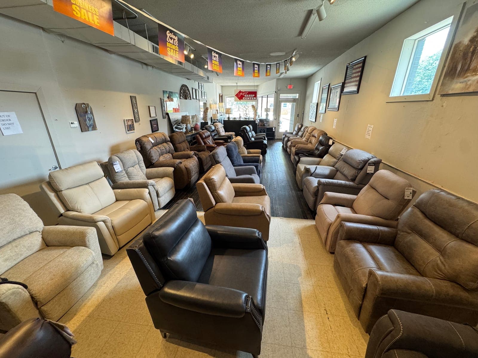 Recliners and leather chairs lined up on the floor at Seneca Furniture Showcase in Seneca, SC