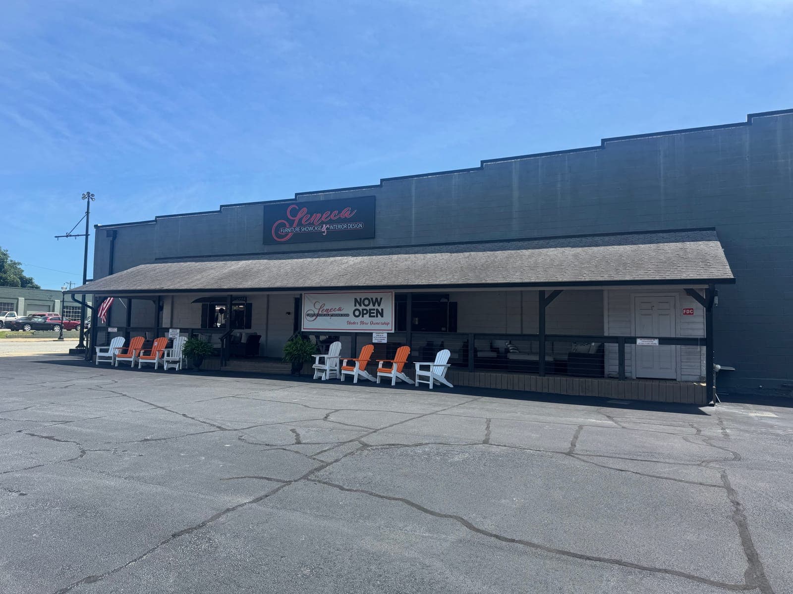 Covered front porch of Seneca Furniture Showcase with Adirondack chairs at 114 N Fairplay St in Seneca, SC